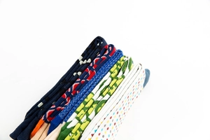 Close-up of stacked colorful knitted crew socks featuring polka dots and geometric patterns