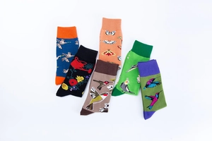 Close-up of cotton socks with vibrant bird, flower, and butterfly patterns in six colors