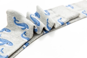 Close-up of gray knitted cotton socks with blue whale pattern and fine texture