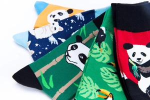 Close-up of colorful mid-calf cotton socks featuring panda and toucan patterns