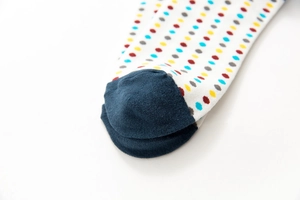Detail of colorful polka dot cotton socks with navy blue toe and fine knit texture