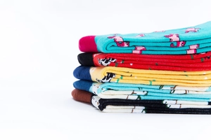Detail von bunten Baumwollsocken mit süßen Flamingo, Kuh und Corgi Tierstrickmustern