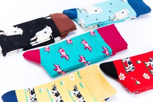 Detail von fünf bunten Socken aus Baumwolle mit Schaf Kuh und Schwein Motiven