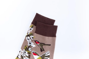 Detailed close-up of hummingbird and floral embroidery on ribbed cotton crew socks