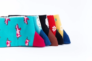 Detailansicht von fünf bunten Baumwollsocken mit Schweine- und Gänseblümchenmustern