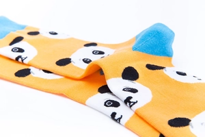 Detail of vibrant orange and blue panda pattern knitted cotton crew socks in folded view