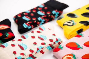 Flat lay view of cotton crew socks featuring various knitted strawberry patterns and colors