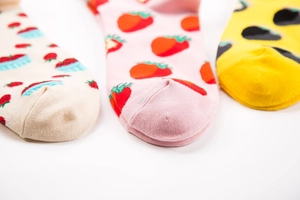 Detailed close-up of colorful cotton socks with strawberry and abstract fruit patterns