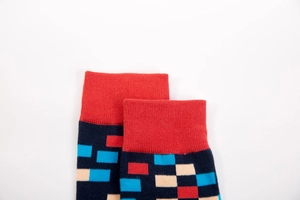 Close-up of red ribbed cuffs and geometric patterns on knit cotton crew socks