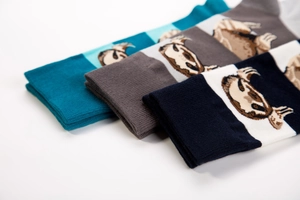 Detailed close-up of sloth embroidery on knit crew socks in blue, gray and navy colors