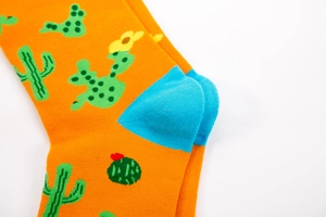 Detailed macro view of orange socks with green cactus pattern and blue contrast heels