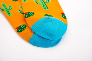 Detail shot of orange cotton socks with green cactus patterns and blue toe contrast stitching