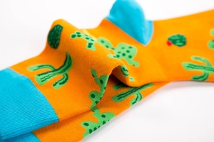 Detailed macro shot of cotton crew socks featuring green cactus patterns in orange and blue