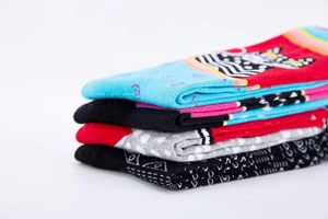 Close-up of assorted mid-calf socks with cat patterns, polka dots, and geometric knits