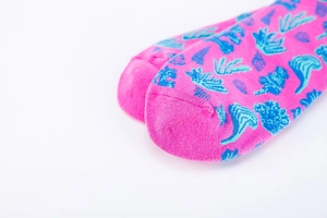 Détail des chaussettes en coton rose avec motifs de corail bleu et coquillages marins