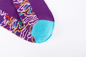 Détail de chaussettes en tricot violettes avec motifs ondulés et talon contrasté