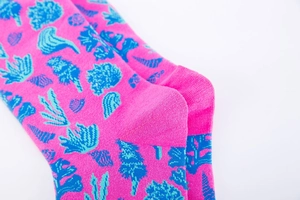 Gros plan de chaussettes mi-mollet rose avec motifs de coraux et coquillages bleus