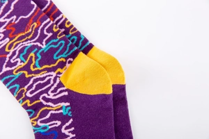 Détail des chaussettes en tricot violet avec motifs abstraits et talon jaune vif