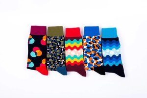 Flat lay of colorful crew socks featuring wave patterns, polka dots, and leopard prints