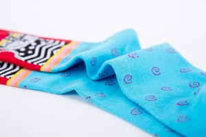 Close-up of bright blue knitted socks with pink spiral patterns and red ribbed cuffs