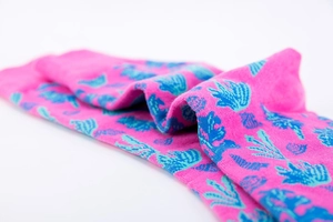 Gros plan détaillé sur des chaussettes en coton rose avec motifs de corail bleus
