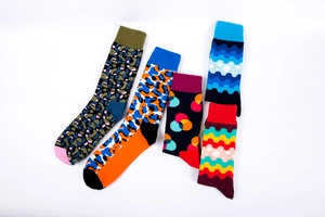 Flat lay of five colorful cotton socks featuring camo, leopard, and polka dot patterns