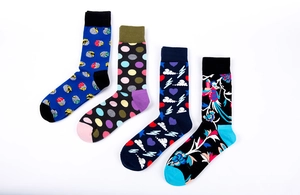 Detailed view of four pairs of colorful men's socks with polka dots and bird patterns