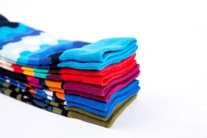 Macro view of stacked colorful cotton crew socks featuring jacquard patterns and ribbed cuffs