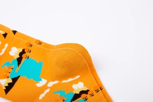 Close-up of abstract mountain pattern and knit texture on orange cotton crew socks