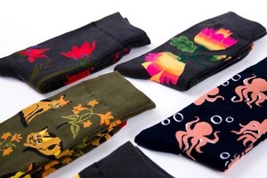 Detailed macro view of four patterned cotton crew socks featuring floral and animal motifs