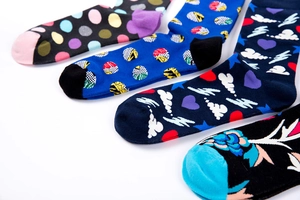 Detail of four colorful patterned cotton mid-calf socks with dots and floral designs