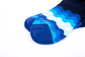 Detailed view of blue geometric wave pattern on cotton socks with durable stitched toe