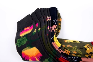 Detailed view of dark floral and cat jacquard patterns on colorful mid-calf cotton socks