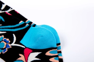Detail of floral jacquard pattern and reinforced light blue heel on black cotton crew socks