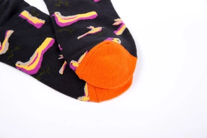 Detailed close-up of cotton socks with dark bird patterns and bright orange toe caps