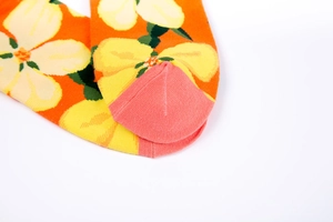 Detail shot of bright orange floral socks with hibiscus patterns and reinforced toe