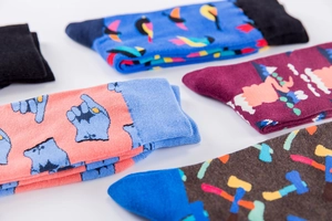 Flat lay of colorful crew socks with artistic gestures and scenic landscape patterns