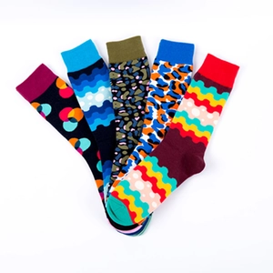 Five pairs of colorful crew socks with vibrant polka dots, leopard, and wave knit patterns