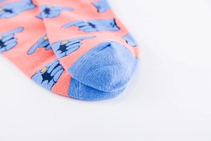 Close-up of orange cotton socks with blue finger patterns and flat toe seam detail