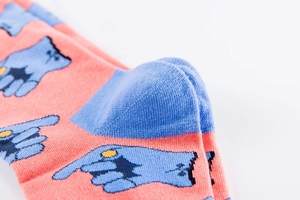 Detailed close-up of coral pink cotton socks featuring reinforced heel and knit texture