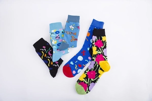 Close-up of four pairs of men's crew socks with colorful geometric and floral patterns