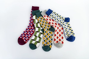 Gros plan de cinq paires de chaussettes en coton aux motifs géométriques colorés variés