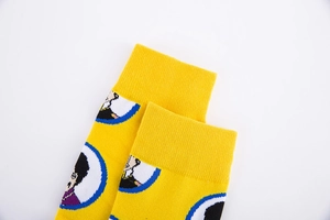 Detailed view of yellow crew socks featuring vibrant cartoon portrait illustrations