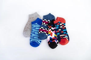 Flat lay detail of five pairs of men's low-cut socks with diverse geometric patterns