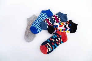 Flat lay of five men's cotton ankle socks featuring assorted geometric jacquard patterns