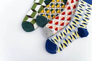 Détail de quatre chaussettes de style britannique aux motifs géométriques et orteils contrastés