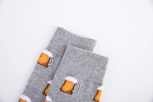Detailed knit of grey cotton crew socks featuring orange pixelated beer mug patterns