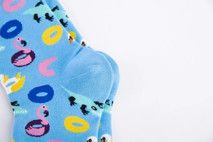 Close-up of light blue socks featuring pink flamingo and small crocodile patterns