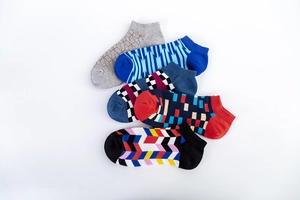 Flat lay of five pairs of men's low-cut socks with geometric patterns and elastic cuffs