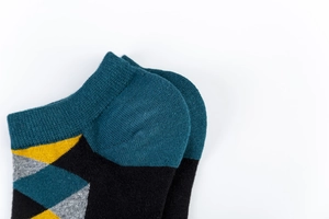 Close-up of geometric diamond pattern and knitted texture on these colorful low cut socks